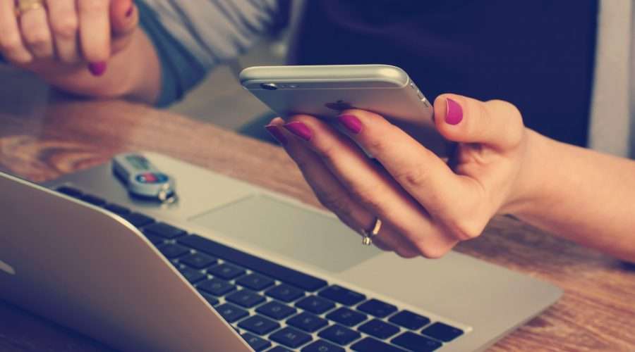 Woman holding silver iPhone