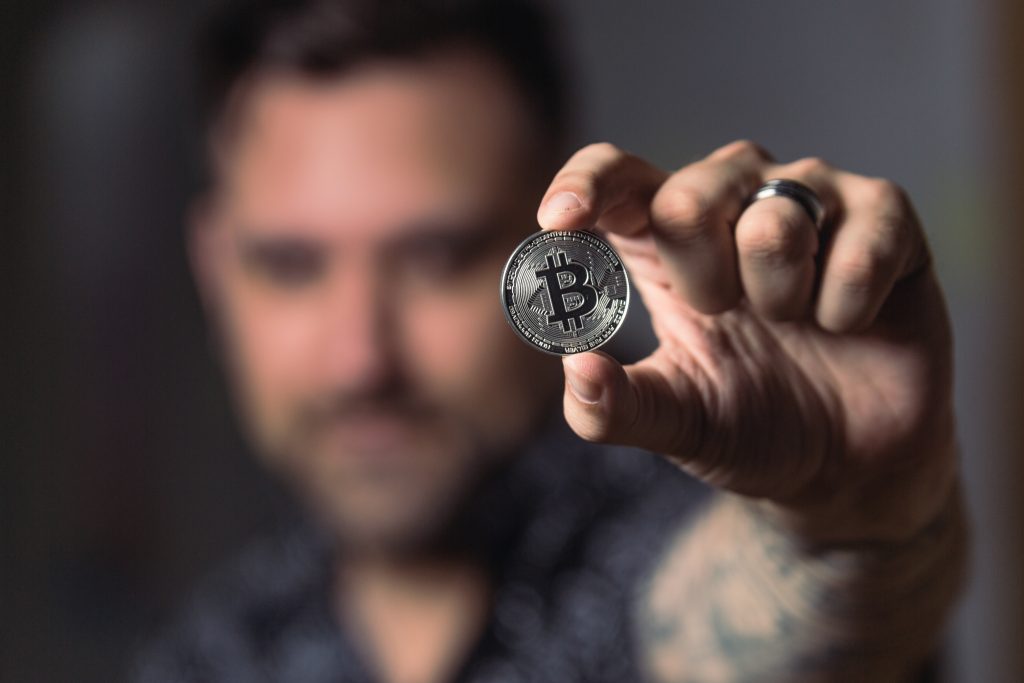 man holding silver bitcoin
