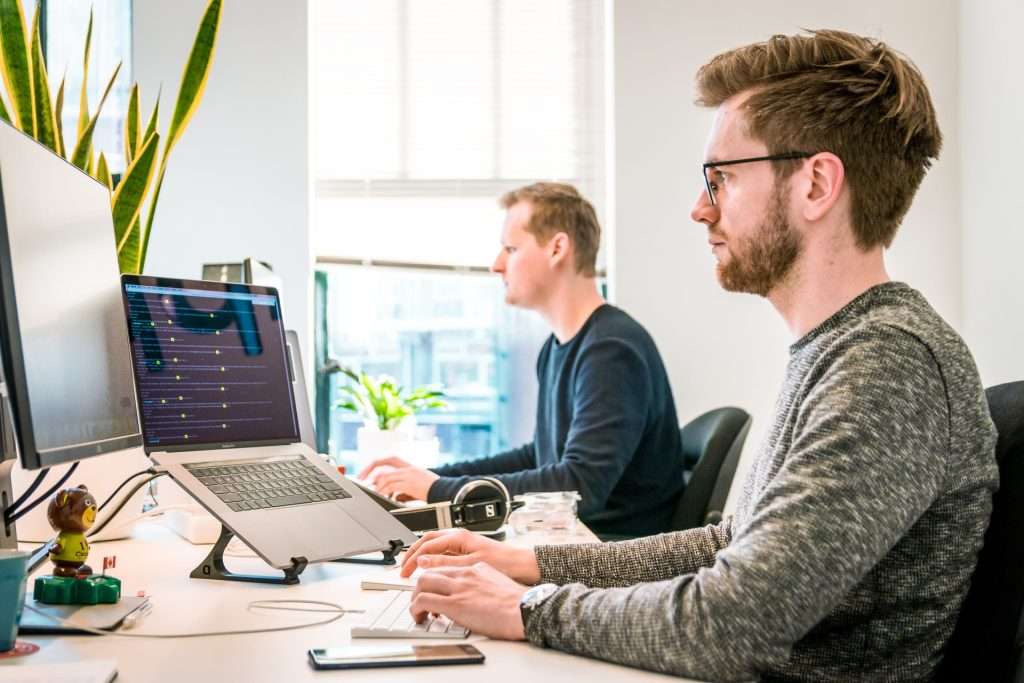 man in grey shirt working on pc