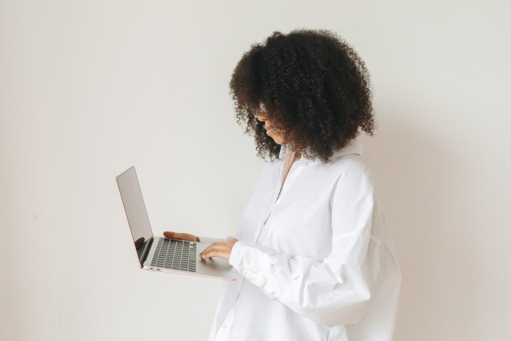 Girl with curly hair holding laptop