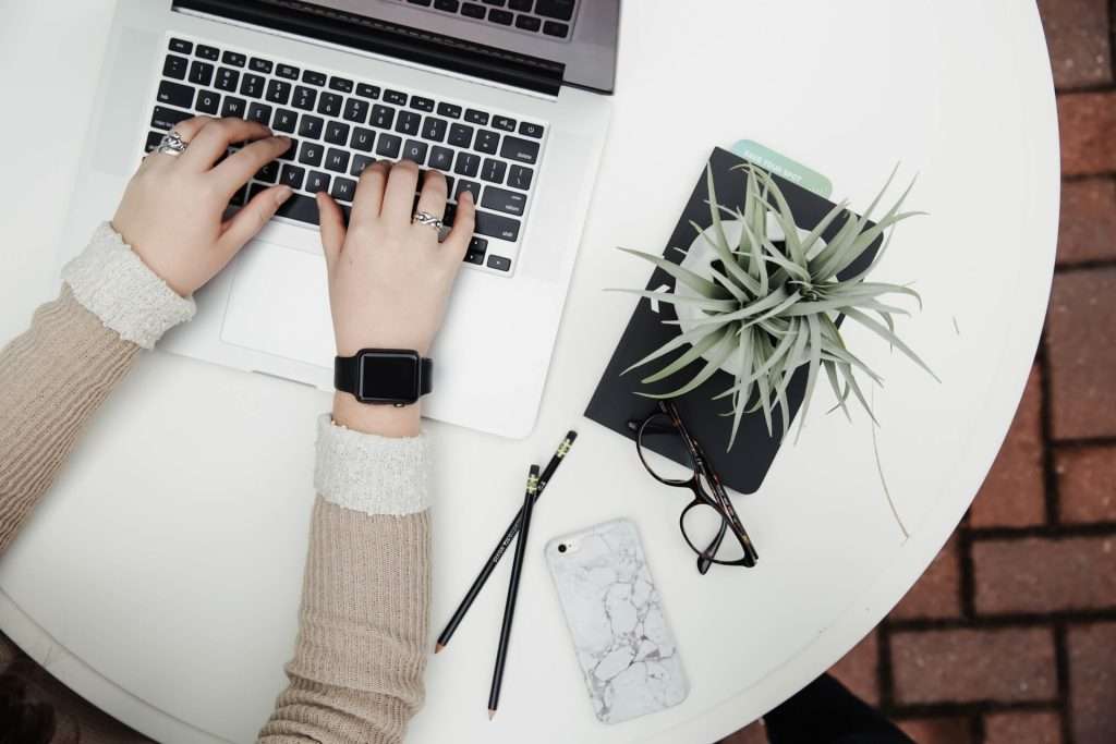 person using laptop on white desk